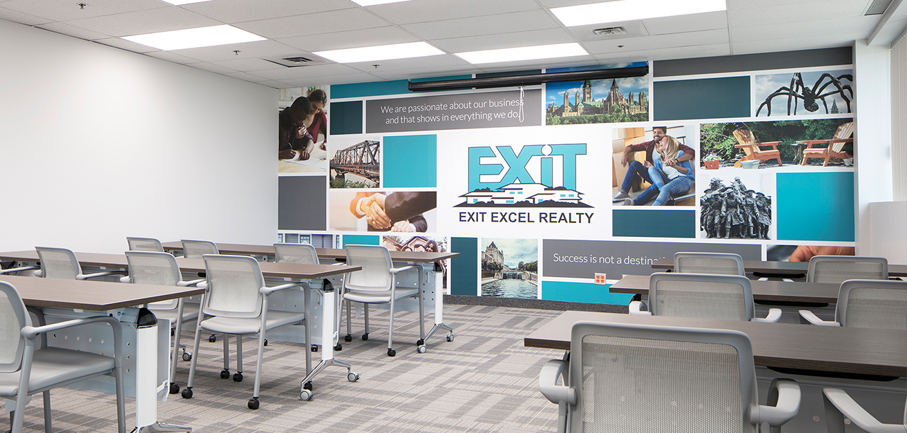 Meeting room with multiple desks and accent branded wall
